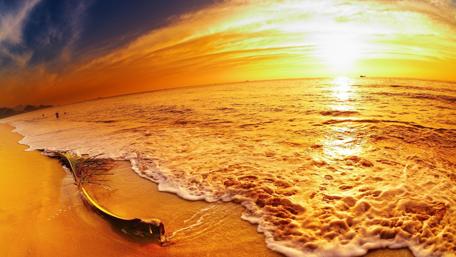 Golden Sunset Over Tranquil Beach Waters wallpaper