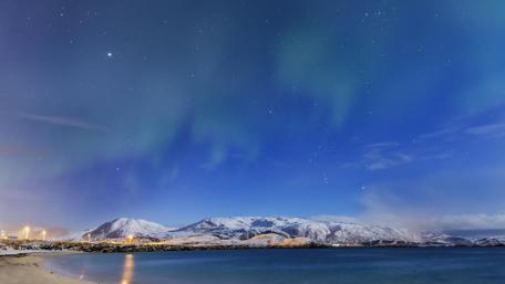 Breathtaking Northern Lights Over Snowy Mountains and Sea wallpaper