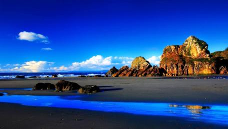 Serene Beachscape Under Brilliant Blue Sky wallpaper