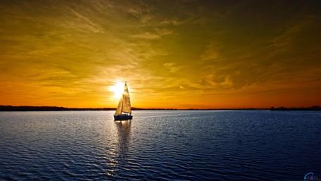 Tranquil Sunset Over Water with Sailing Boat wallpaper