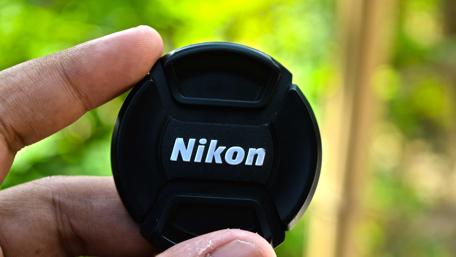 Nikon DSLR Lens Cap in Nature Setting wallpaper