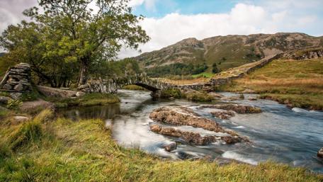 Stone Bridge Over Serene River Landscape wallpaper