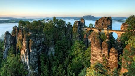 Misty Cliffside Bridge in Serene Nature wallpaper