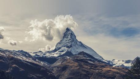Majestic Peaks Under a Cloudy Sky wallpaper