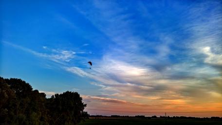 Serene Sunset Over Fields with Paraglider wallpaper