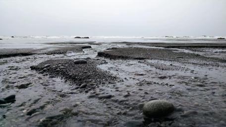 Serene Black Beach Under Rainy Skies wallpaper