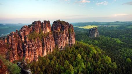 Majestic Cliffs Surrounded by Lush Forests wallpaper