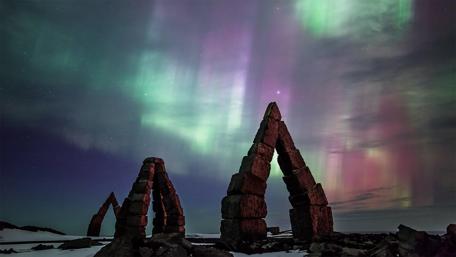 Mystical Northern Lights Over Ancient Stone Arches wallpaper