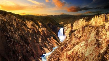 Majestic Waterfall Amidst Rugged Cliffs wallpaper