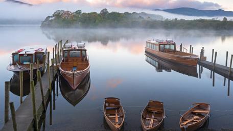 Boats Resting on Peaceful Misty Lake wallpaper