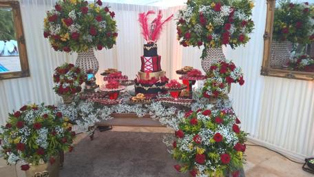 Elegant Celebration Cake Display with Floral Arrangements wallpaper