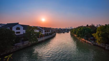 Serene City Sunset Over Tranquil River Waters wallpaper