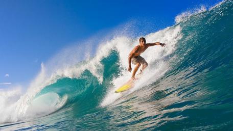 Thrilling Surfing Adventure Under Bright Blue Skies wallpaper