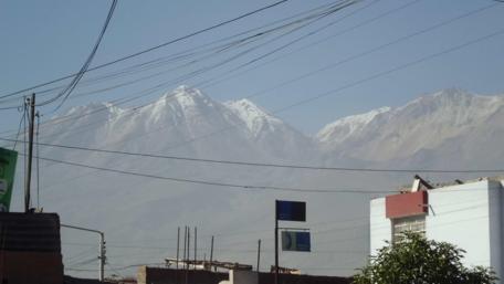 Majestic Mountains Overhead in Urban Landscape wallpaper
