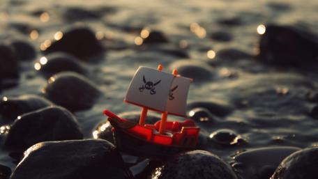 Tiny Pirate Ship on a Stony Shore wallpaper