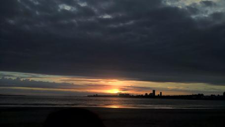 Serene Sunset Over the City Beach View wallpaper