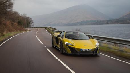Sleek McLaren 675LT Spider on a Scenic Road wallpaper