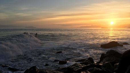 Sunset Surfing Adventure Over Crystal Waves wallpaper