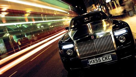 Elegant Rolls Royce in Motion at Nighttime wallpaper