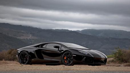 Sleek Black Dream Car Against a Dramatic Landscape wallpaper