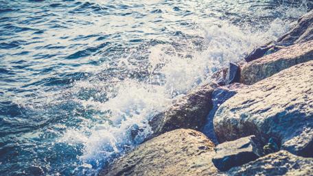 Gentle Waves Embracing Rocky Shores wallpaper