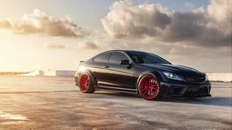 Sleek Black Car with Red Accents in Sunset Glow wallpaper