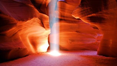 Mystical Cave Illuminated by Light Beam wallpaper