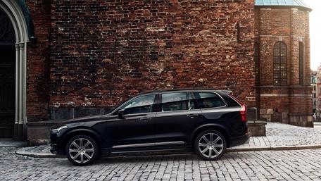 Sleek Black SUV Against Rustic Brick Wall wallpaper
