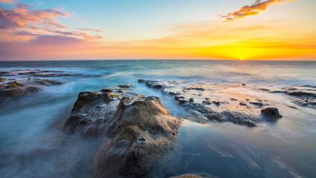 Calm Sunset Over Rocky Shoreline wallpaper