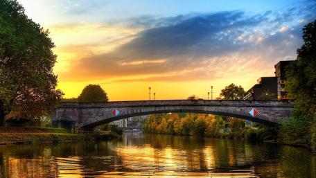 Serene Sunset Over Urban River Scene wallpaper
