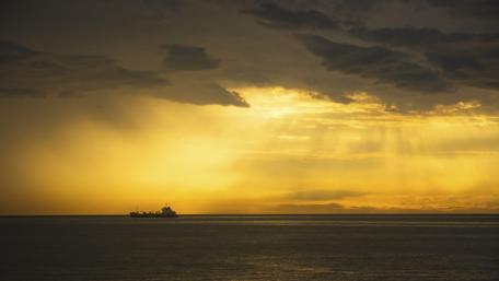 Golden Horizon with a Ship Silhouette wallpaper