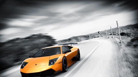 Sleek Orange Lamborghini on a Highway Ride wallpaper