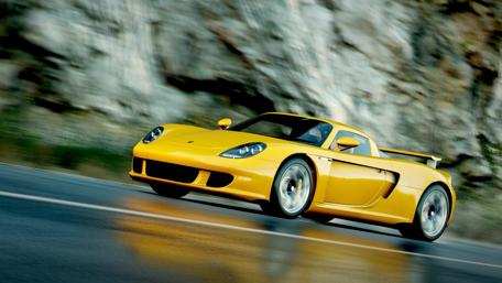 Yellow Porsche Racing on Mountain Road wallpaper