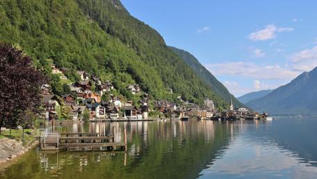 Serene Village by the Water Under Blue Skies wallpaper