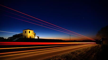 Serene Night Road with Starry Skies and Light Trails wallpaper