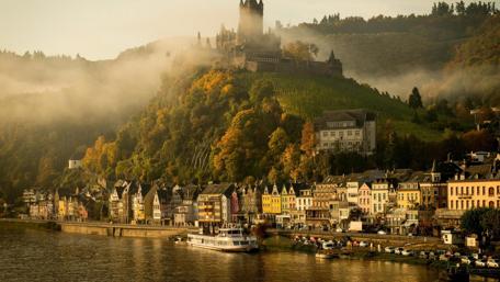 Enchanting Castle Overlooking a Serene River wallpaper