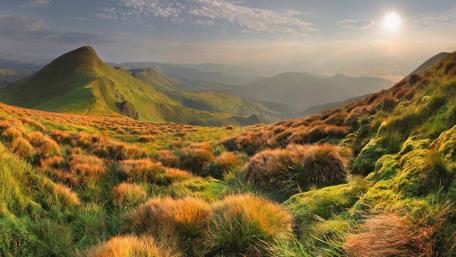 Serene Mountain Sunset Over Lush Fields wallpaper