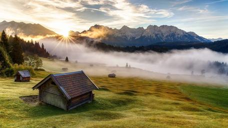 Sunrise Over a Misty Cottage Field wallpaper