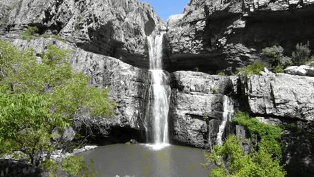 Majestic Waterfall Cascading Through Rocky Cliffs wallpaper