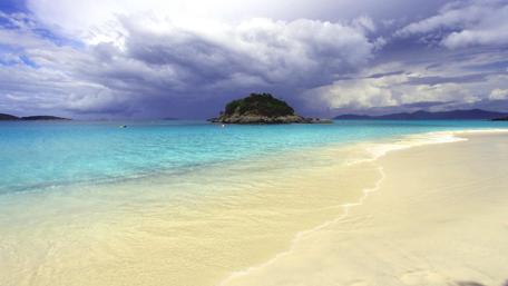 Serene Shoreline With Azure Waters and Dramatic Clouds wallpaper