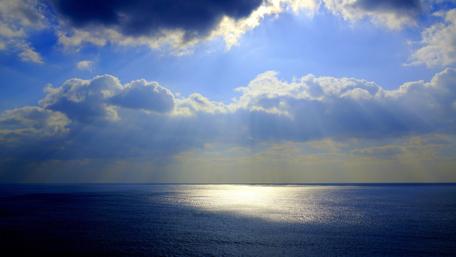 Sunlit Horizon over Tranquil Ocean Waters wallpaper
