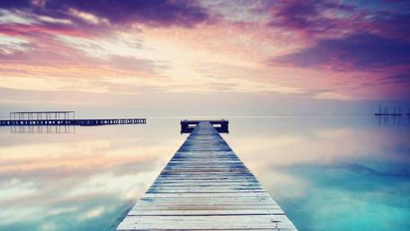 Serene Pier at Dawn Over Calm Waters wallpaper