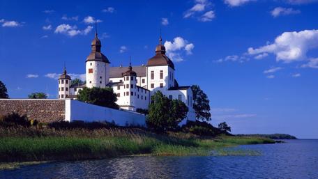 Majestic Castle by the Shore Under a Blue Sky wallpaper