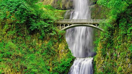 Majestic Waterfall Over a Scenic Bridge wallpaper