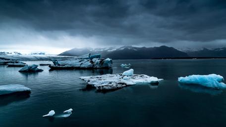 Serene Winter Lake Under Dark Clouds wallpaper