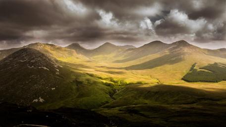 Majestic Hills Under a Cloudy Sky wallpaper