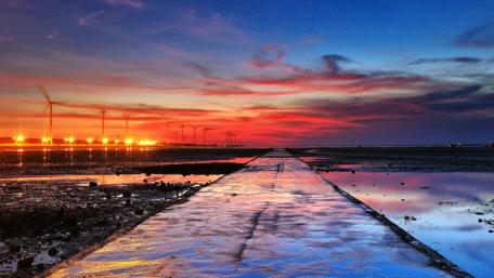 Breathtaking Sunset Over Windmills and Calm Waters wallpaper