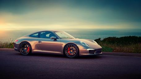 Sleek Porsche on Coastal Road Wallpaper wallpaper