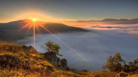 Golden Sunset Over Majestic Mountains and Clouds wallpaper