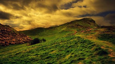 Serene Hillside Under Dramatic Skies wallpaper